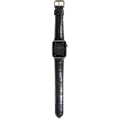 Black crocodile leather watch strap for Apple Watch with a silver buckle, flat lay.
