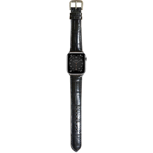 Black crocodile leather watch strap for Apple Watch with a silver buckle, flat lay.