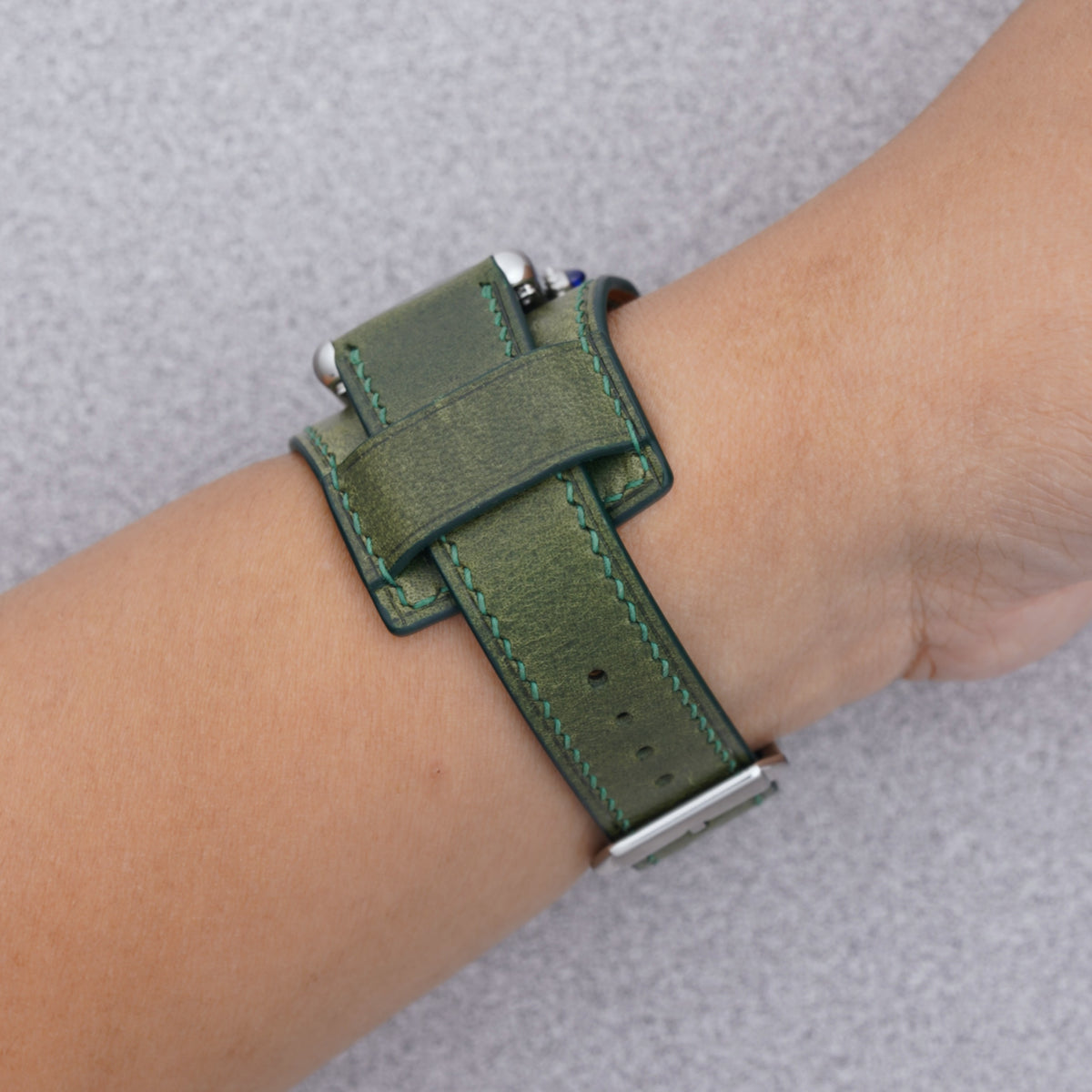 Cartier Tank Must with a green Buttero leather bund strap, strap detail on the wrist