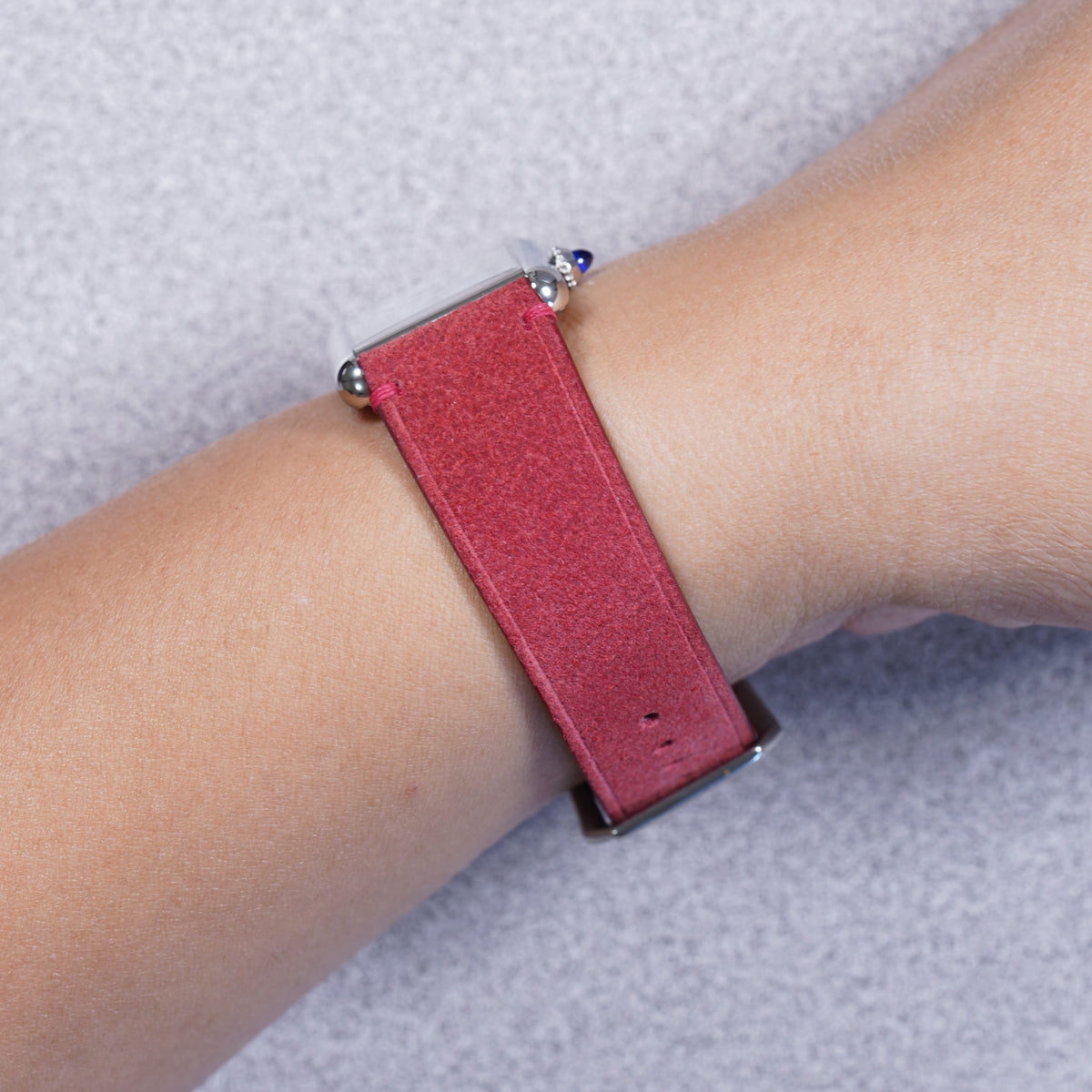Cartier Tank Must with a red suede leather strap, strap detail on the wrist