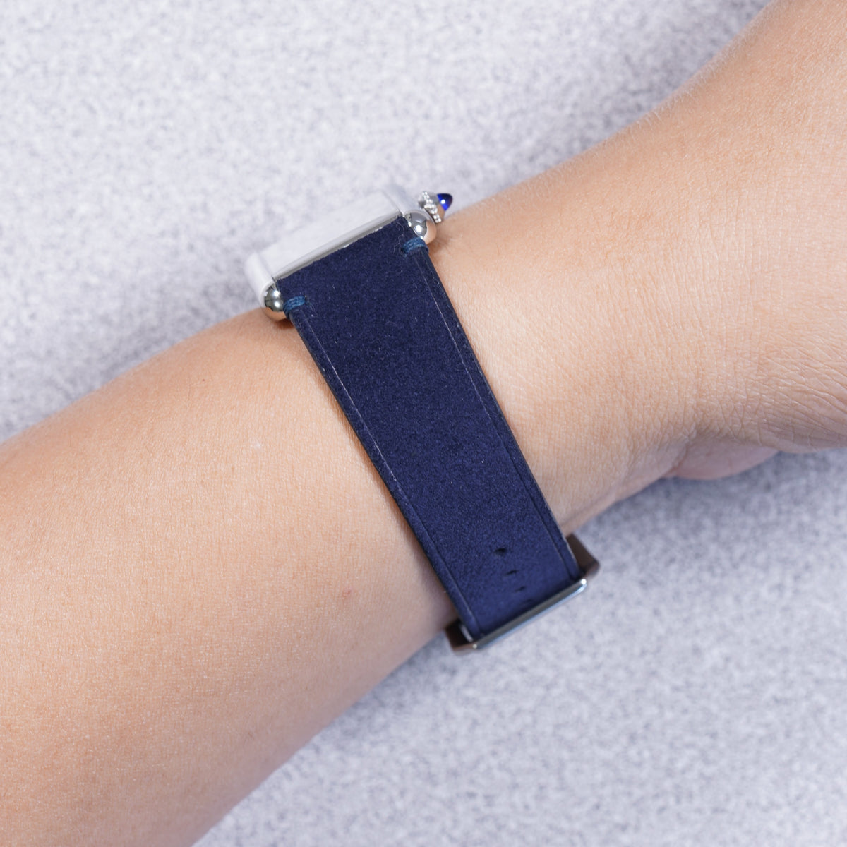 Cartier Tank Must with a midnight blue suede strap, strap detail on the wrist