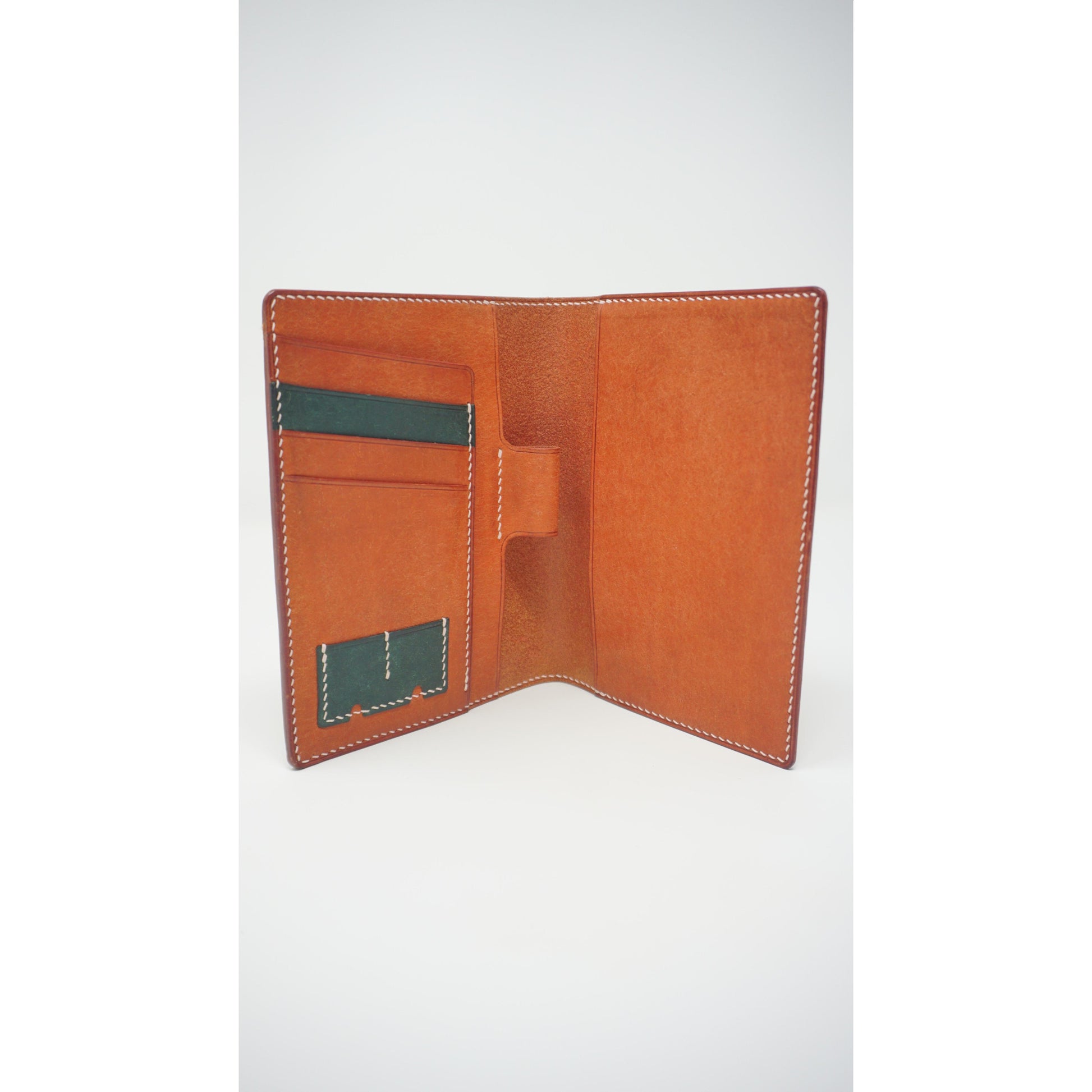 Open Rosy Maya leather passport holder with green card slots and white stitching.