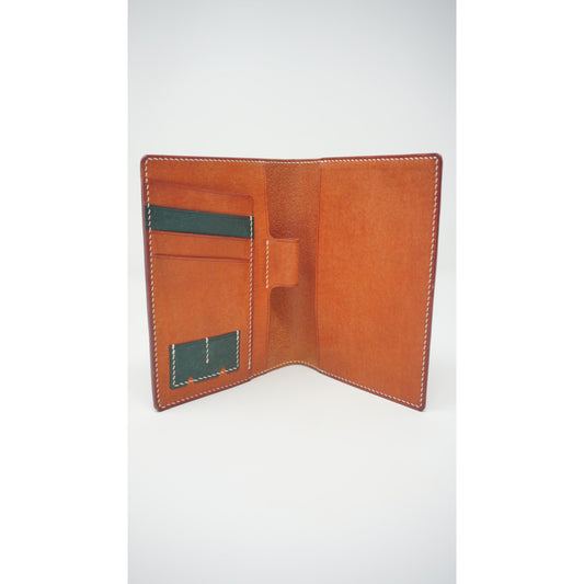 Open Rosy Maya leather passport holder with green card slots and white stitching.
