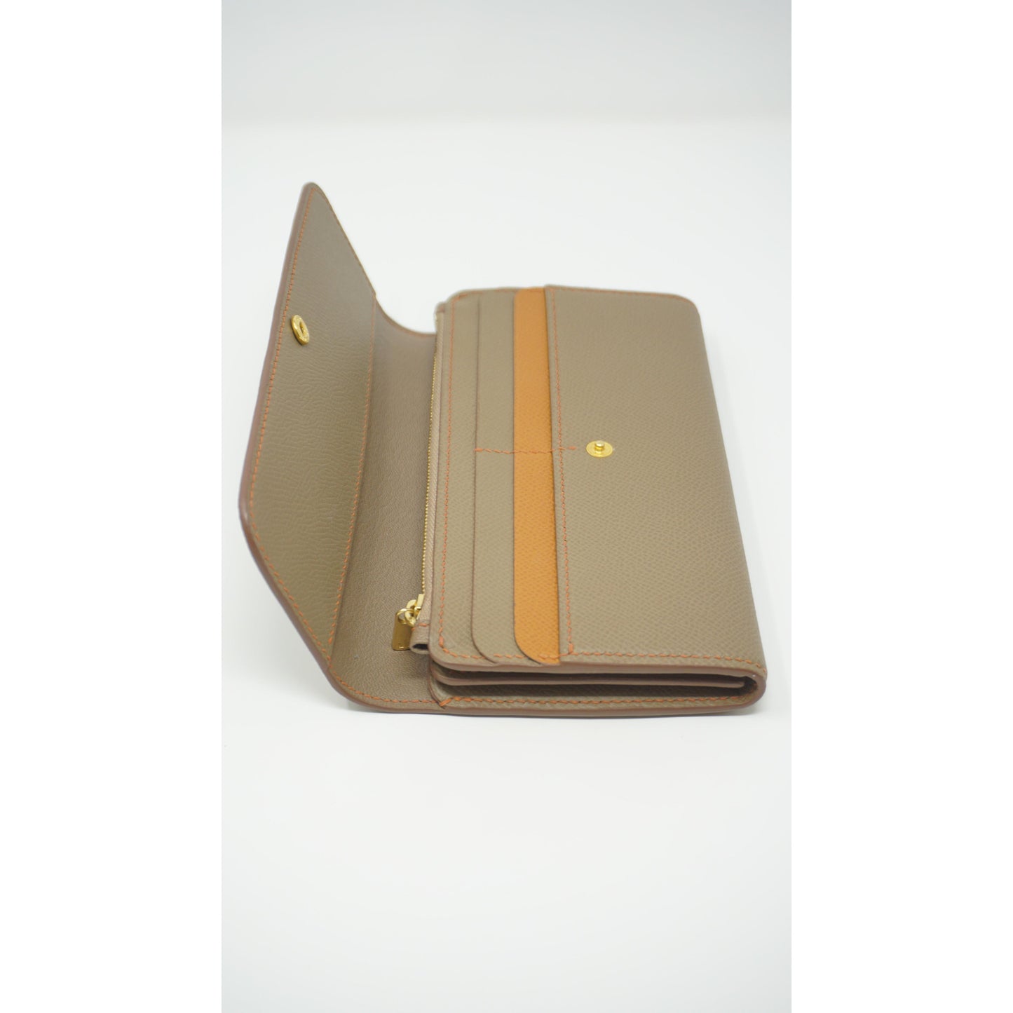 Epsom leather clutch wallet in taupe with orange stitching and accent, open with gold hardware.