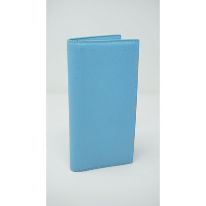Light blue Epsom leather clutch with white stitching, standing upright.