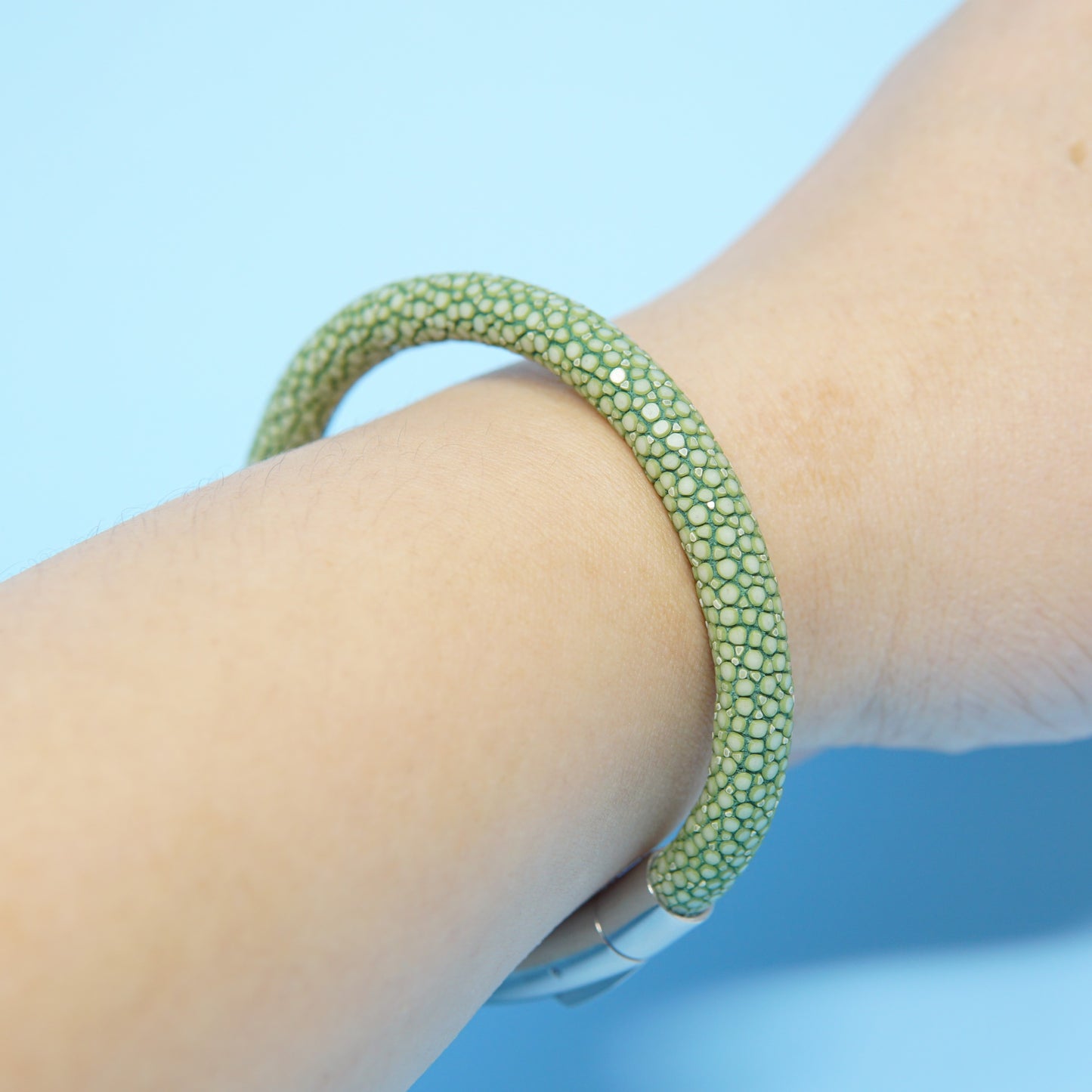 Green stingray leather watch strap bracelet on a wrist, with a silver clasp.