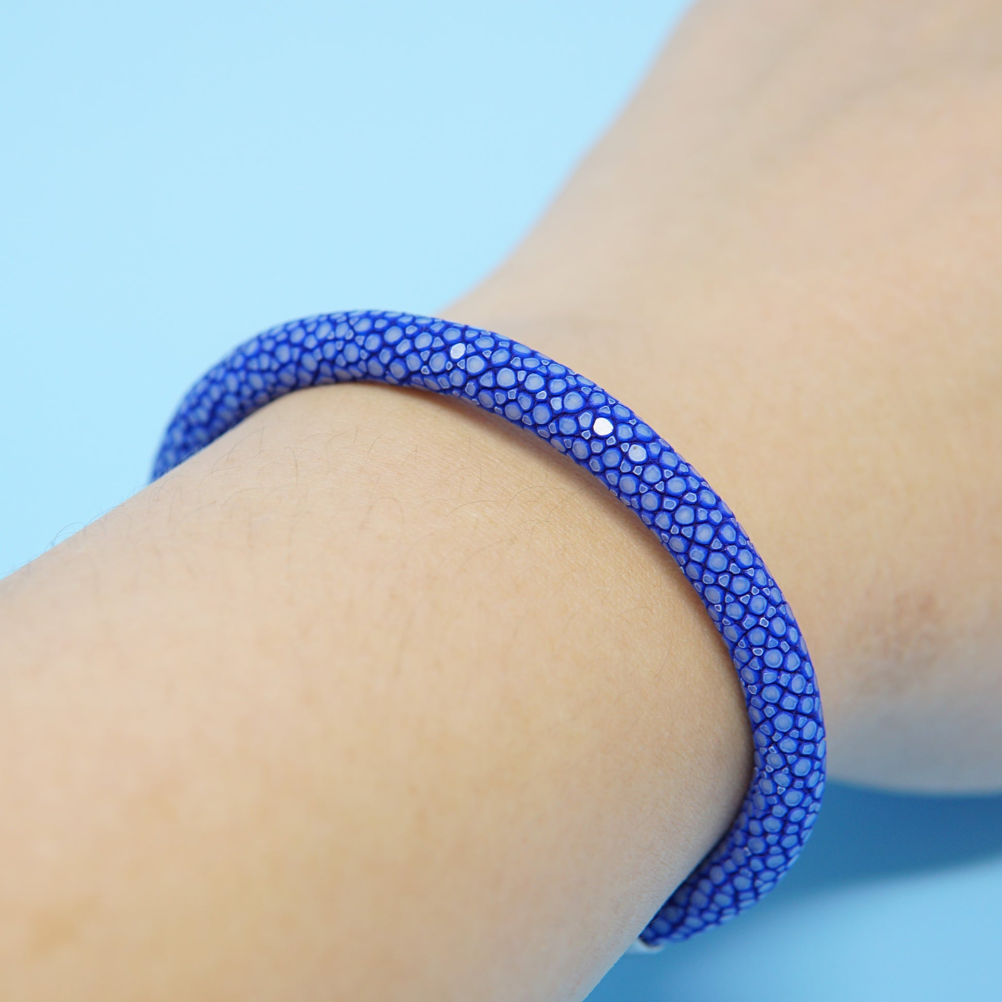 Blue stingray leather watch strap bracelet on wrist, close-up detail.
