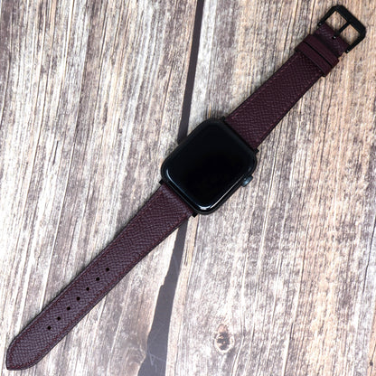 Burgundy Epsom leather watch strap for Apple Watch with black buckle, flat lay.