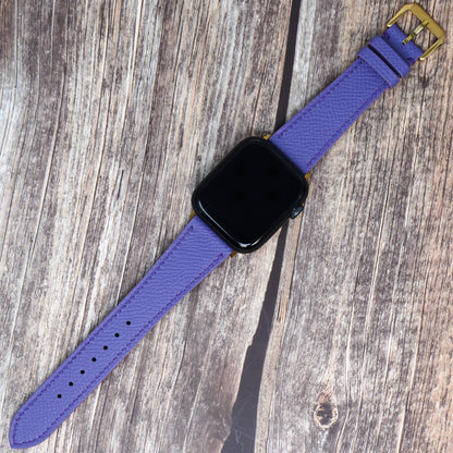 Purple Epsom leather watch strap with gold buckle, flat lay.