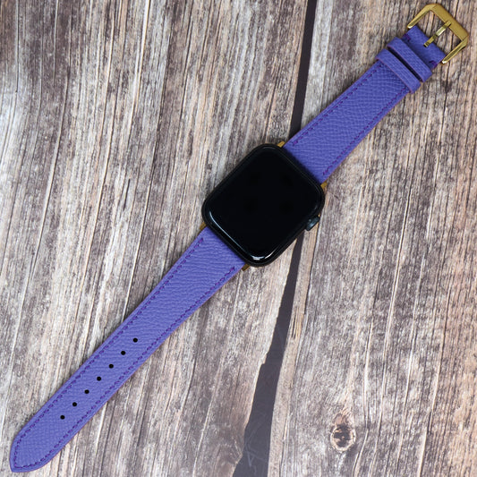 Purple Epsom leather watch strap with gold buckle, flat lay.