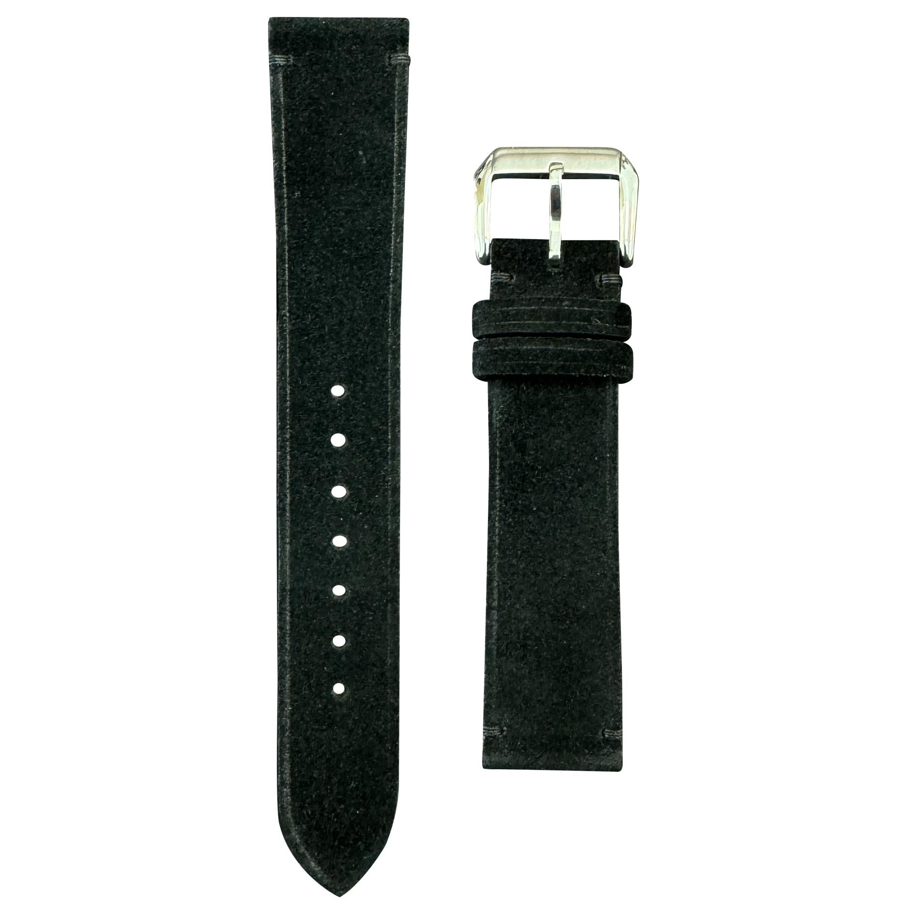 Black suede leather watch strap with a silver buckle, flat lay.