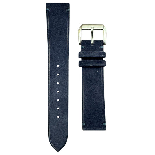 Midnight blue suede leather watch strap with light blue stitching and silver buckle, flat lay.
