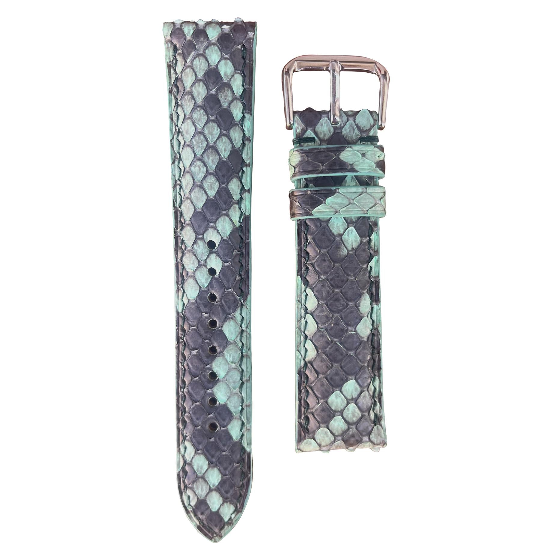 Green snake skin leather watch strap with silver buckle, flat lay.