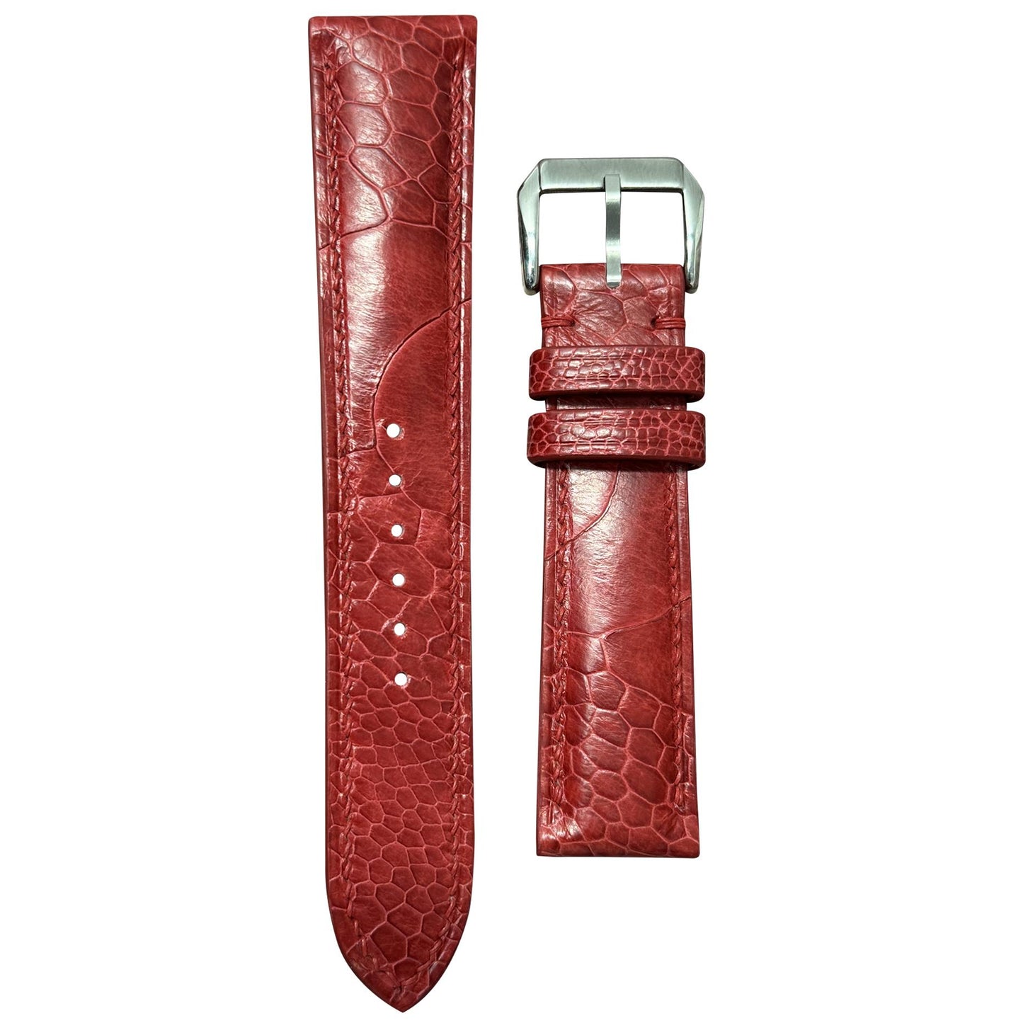 Red ostrich leg leather watch strap with silver buckle, flat lay.