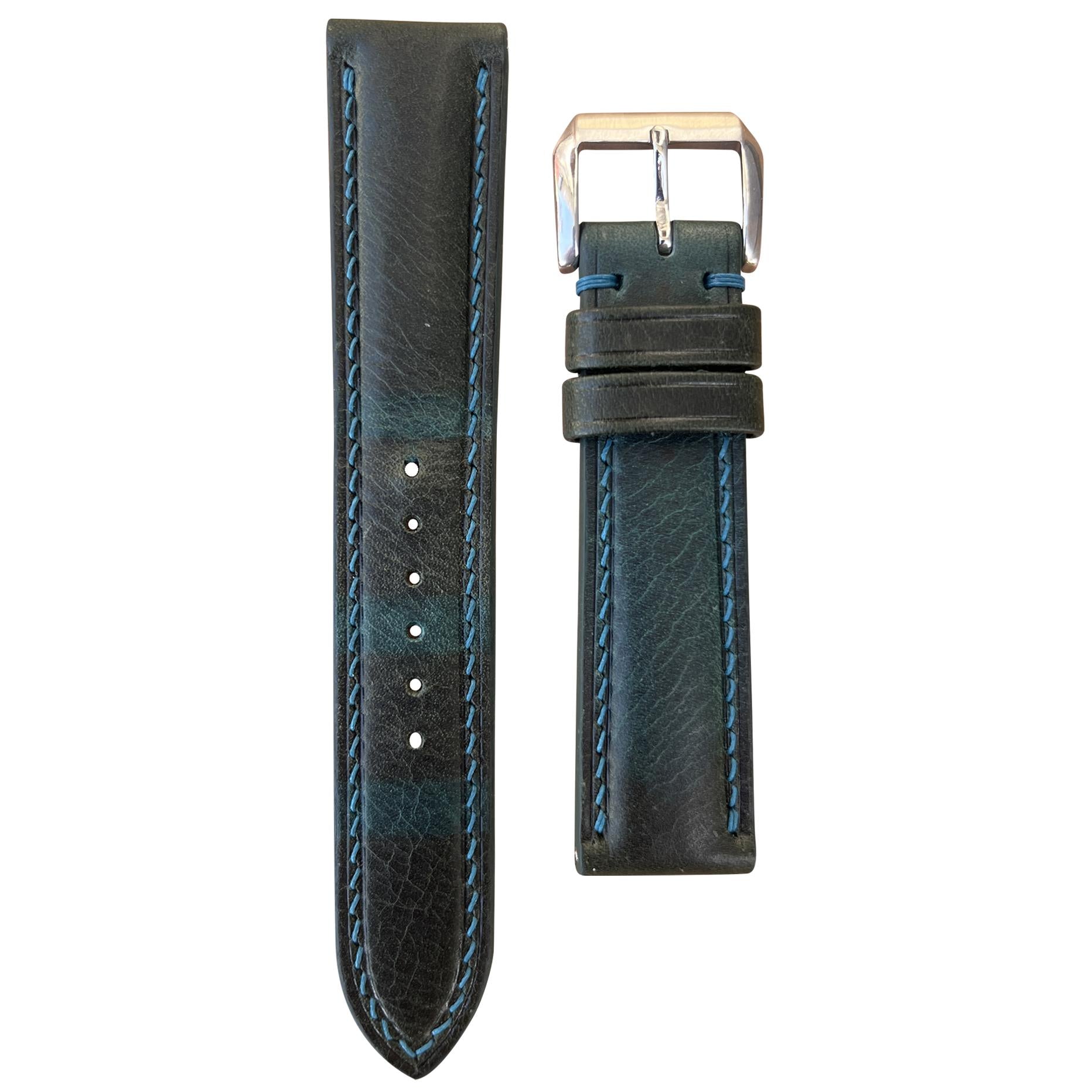 Teal Badalassi Wax leather watch strap with light blue stitching and silver buckle, flat lay.
