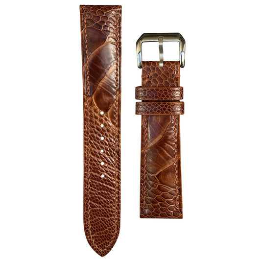 Rooibos Tea ostrich leg leather watch strap with brown stitching and silver buckle, flat lay.