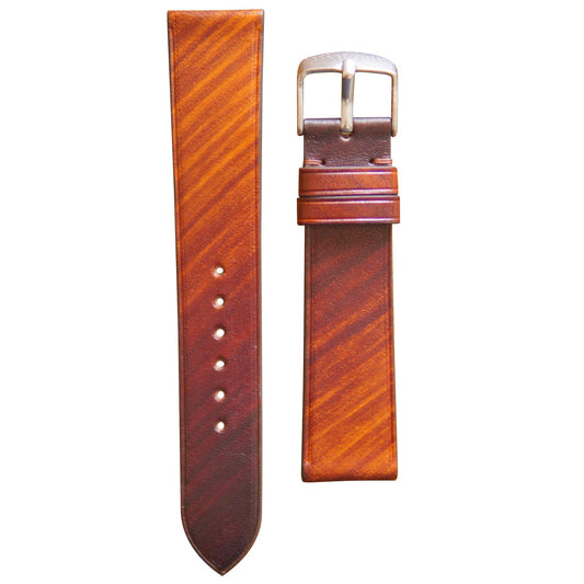 Patina brown leather watch strap with a silver buckle, flat lay.