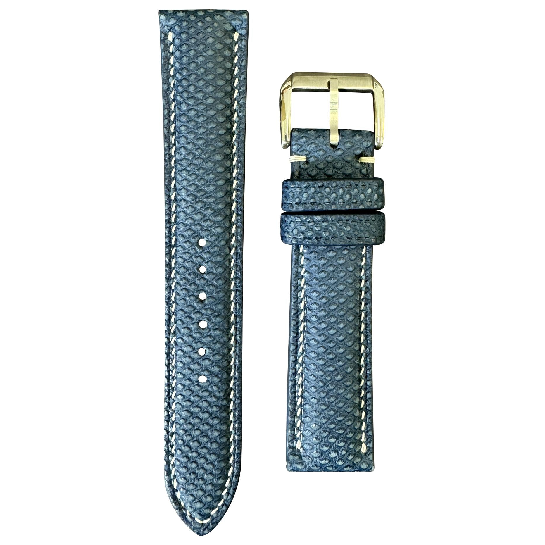 Navy Karung snake skin leather watch strap with white stitching and gold buckle, flat lay.