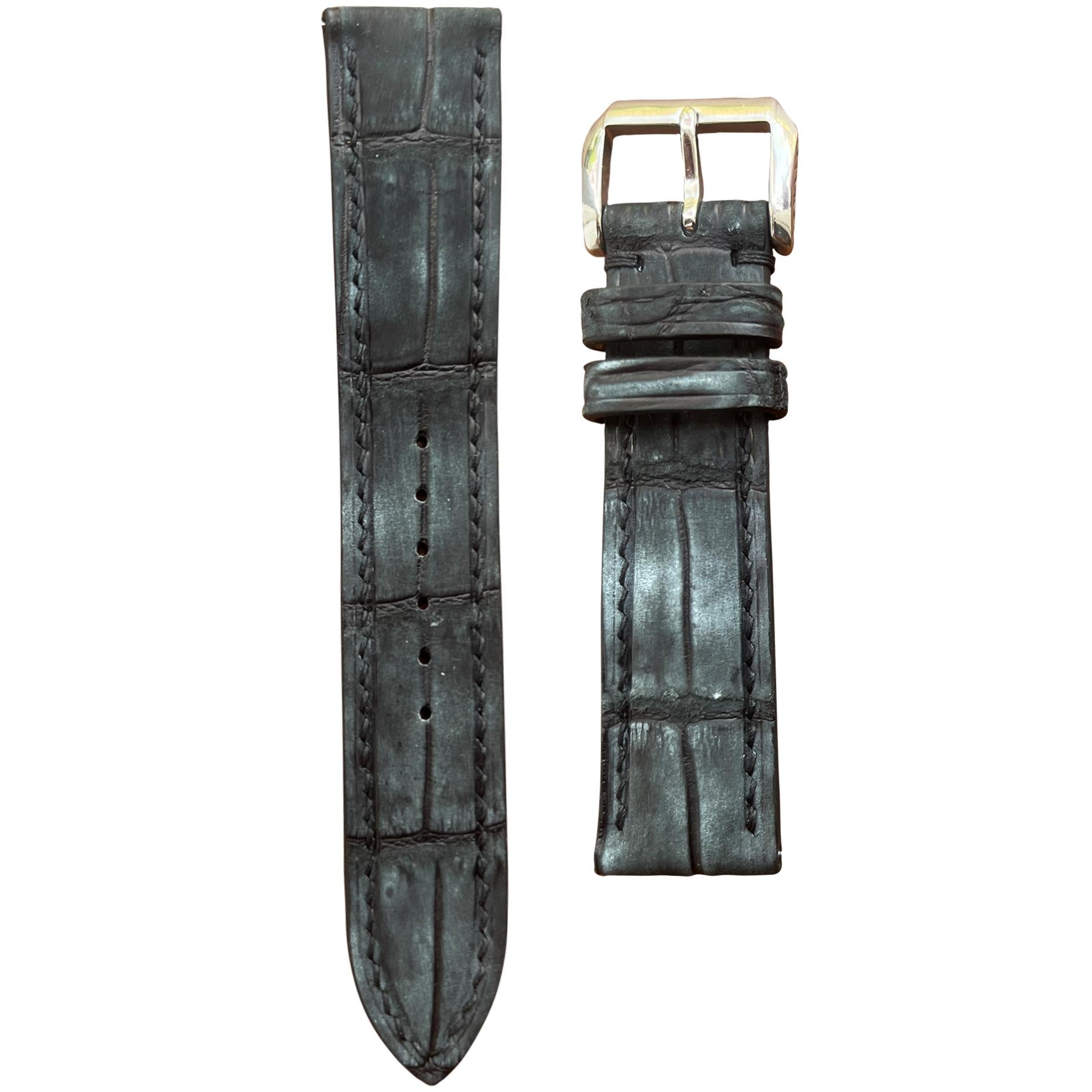 Black nubuck crocodile leather watch strap with matching stitching and silver buckle, flat lay.