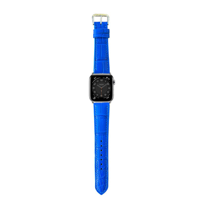 Blue crocodile leather watch strap with silver buckle, flat lay.