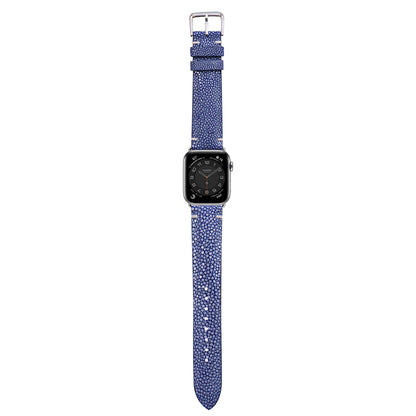 Blue stingray leather watch strap with silver buckle, attached to an Apple Watch, flat lay.