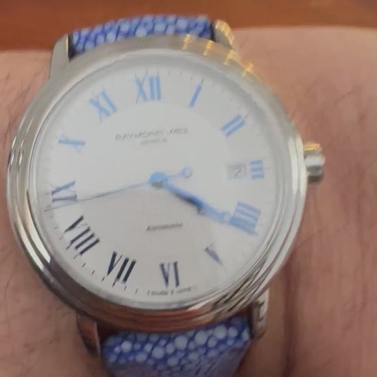 Customer wrist showing a blue stingray leather watch strap with close-up grain, keeper and buckle details.