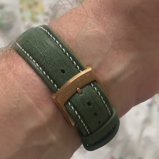 Green Verde Linen custom curved-end leather watch strap fitted to a bronze watch, shown from front and buckle-side customer video views.