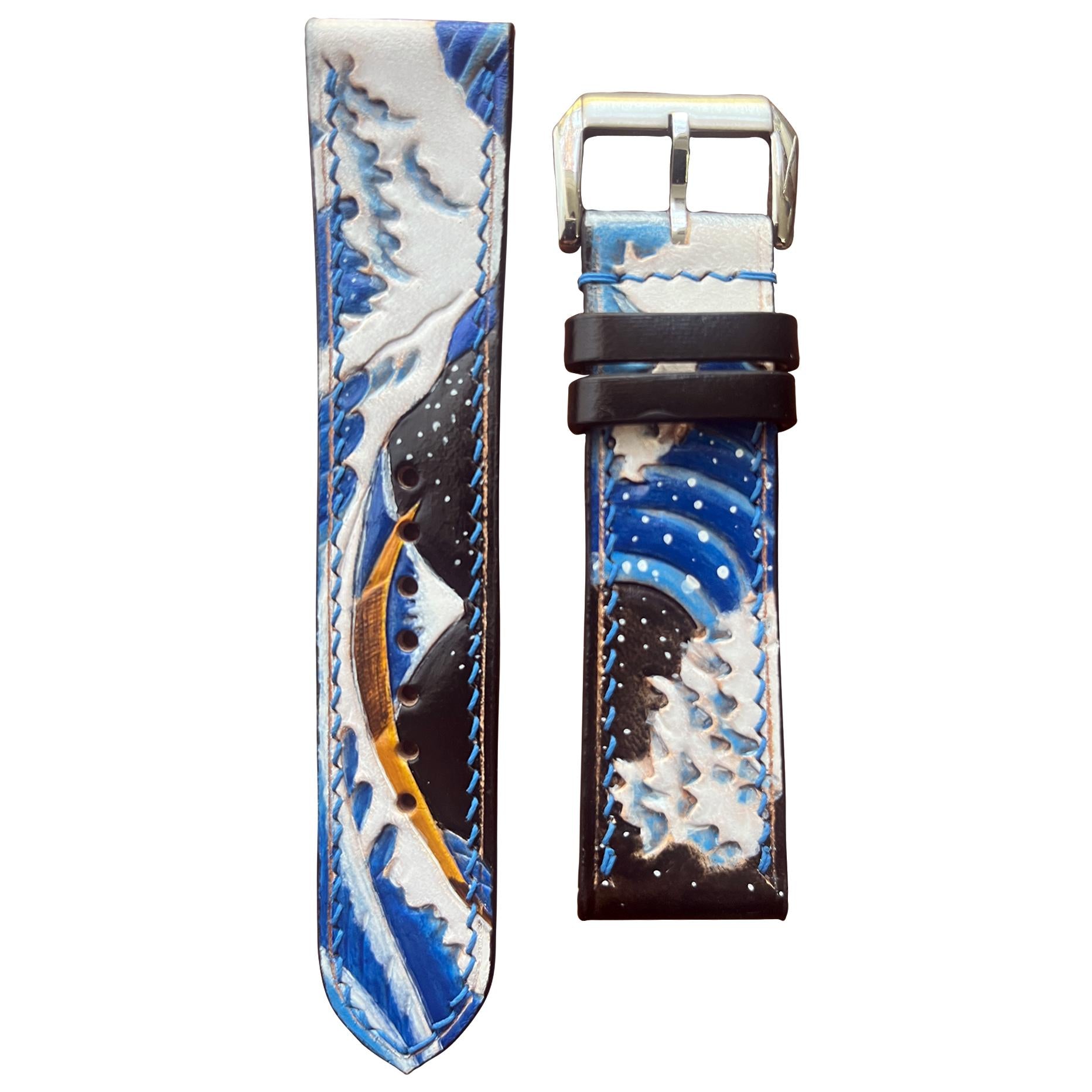 Engraved leather watch strap with "Great Wave" design, blue and white colors, black stitching, and silver buckle.