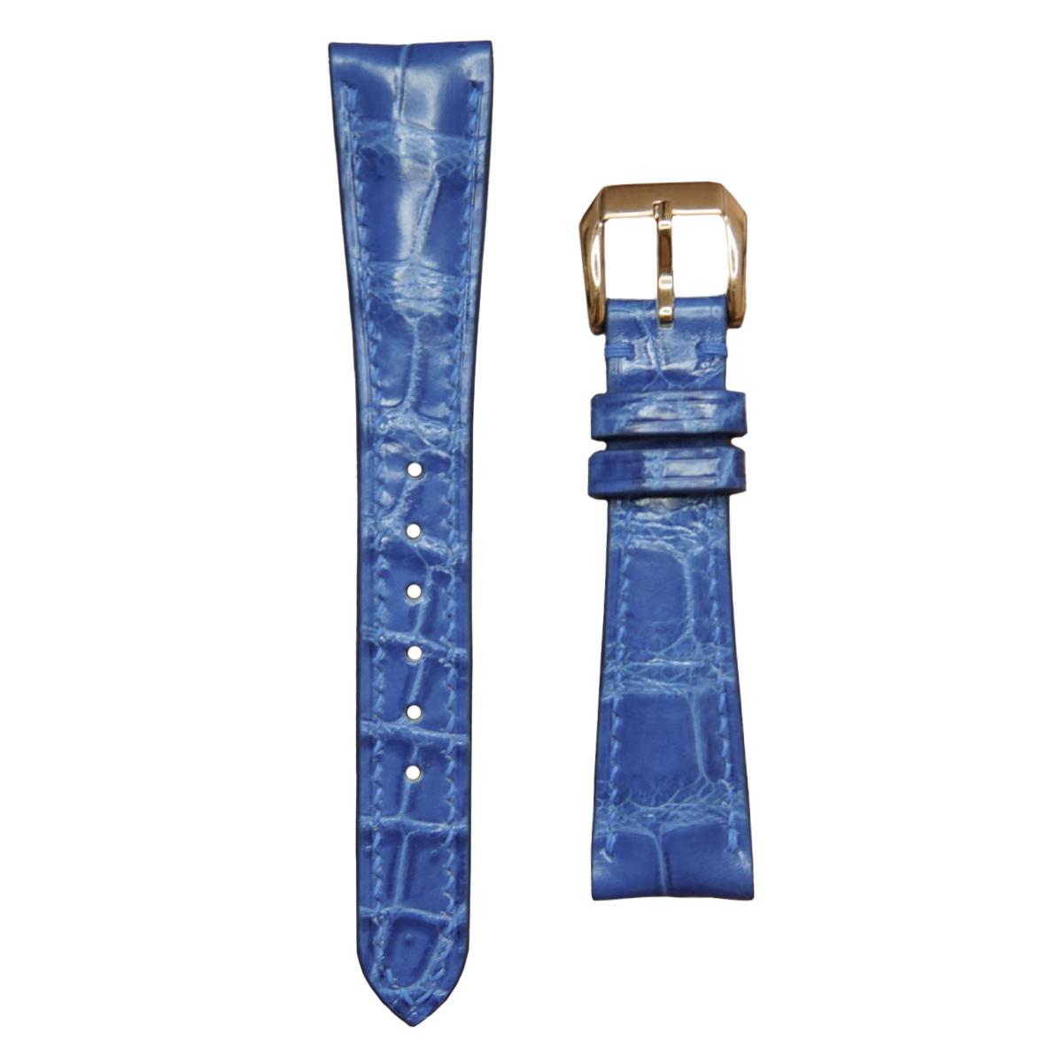 Ocean blue crocodile leather watch strap with gold buckle, flat lay.