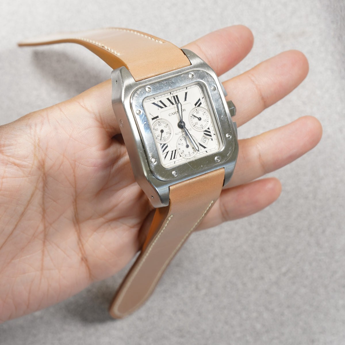 VGreen natural shell cordovan strap on a Cartier Santos 100 XL Chronograph, held in hand