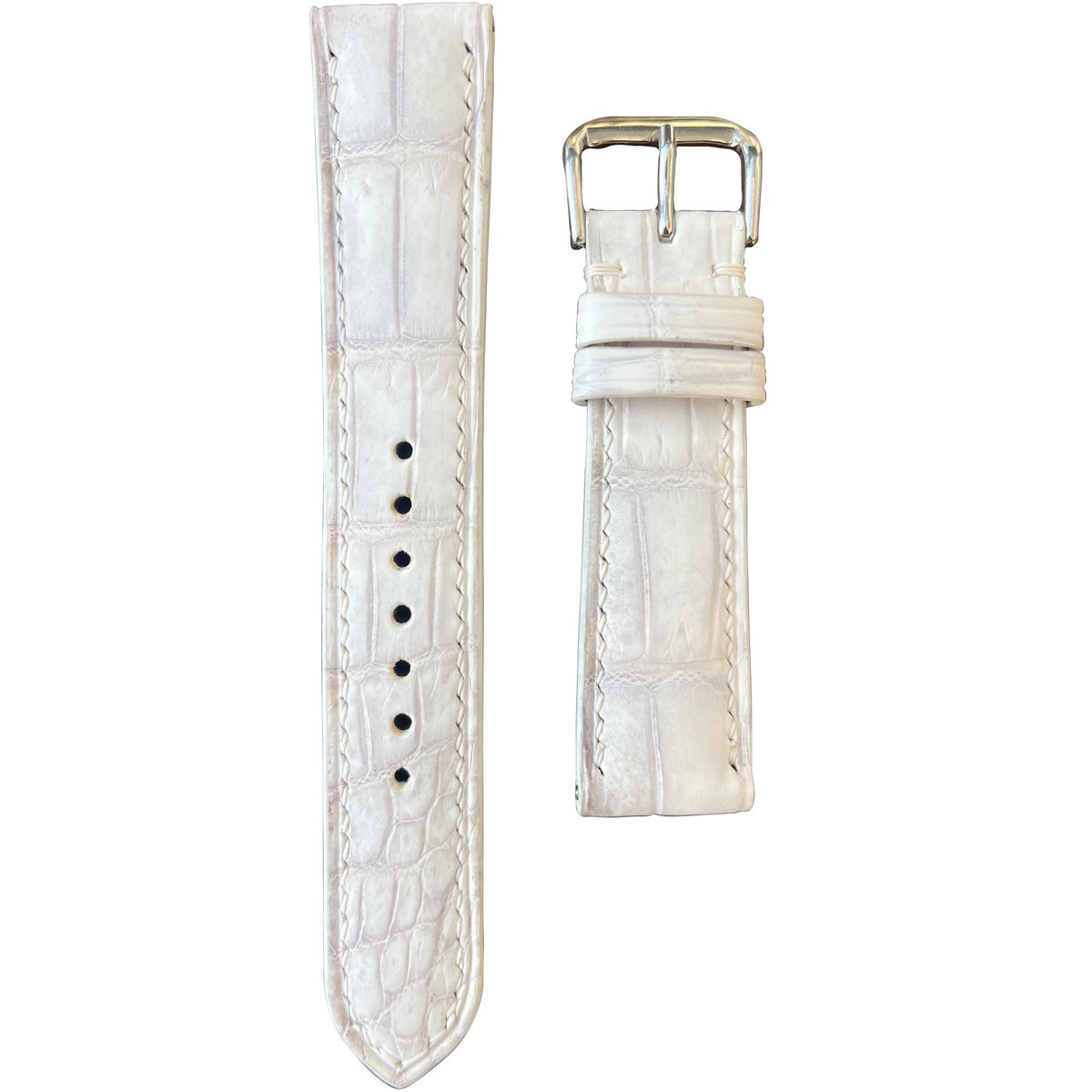 Sand white crocodile leather watch strap with white stitching and silver buckle, flat lay.