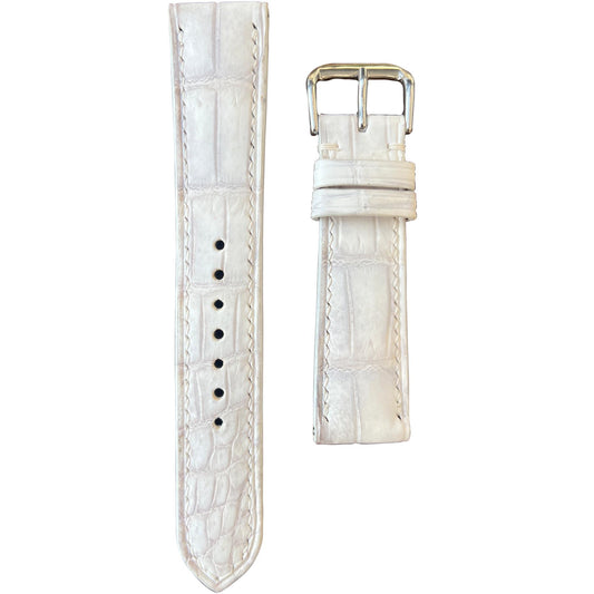 Sand white crocodile leather watch strap with white stitching and silver buckle, flat lay.